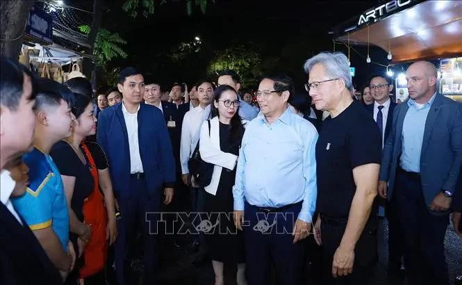 El primer ministro vietnamita, Pham Minh Chinh, y el fundador y presidente del gigante tecnológico NVIDIA, Jensen Huang, se reúnen con pobladores y turistas. (Fuente: VNA)