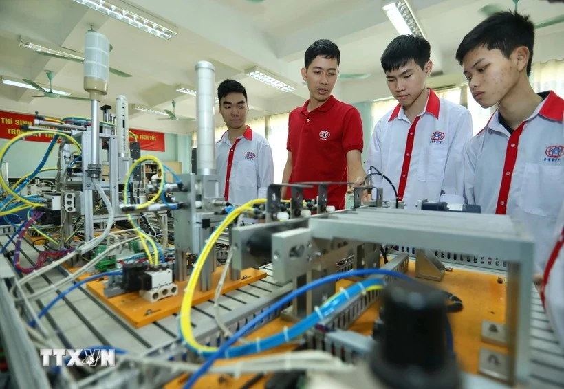 Présentation de modèles d'automatisation aux étudiants de la classe d'électronique industrielle K13 du Collège professionnel de haute technologie de Hanoi. Photo : Hoang Hieu/VNA