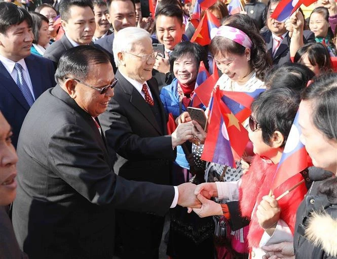 Le secrétaire général Nguyen Phu Trong et le secrétaire général et président du Laos Bounnhang Vorachith et des habitants de Hanoï, le matin du 19 décembre 2017. Photo : VNA