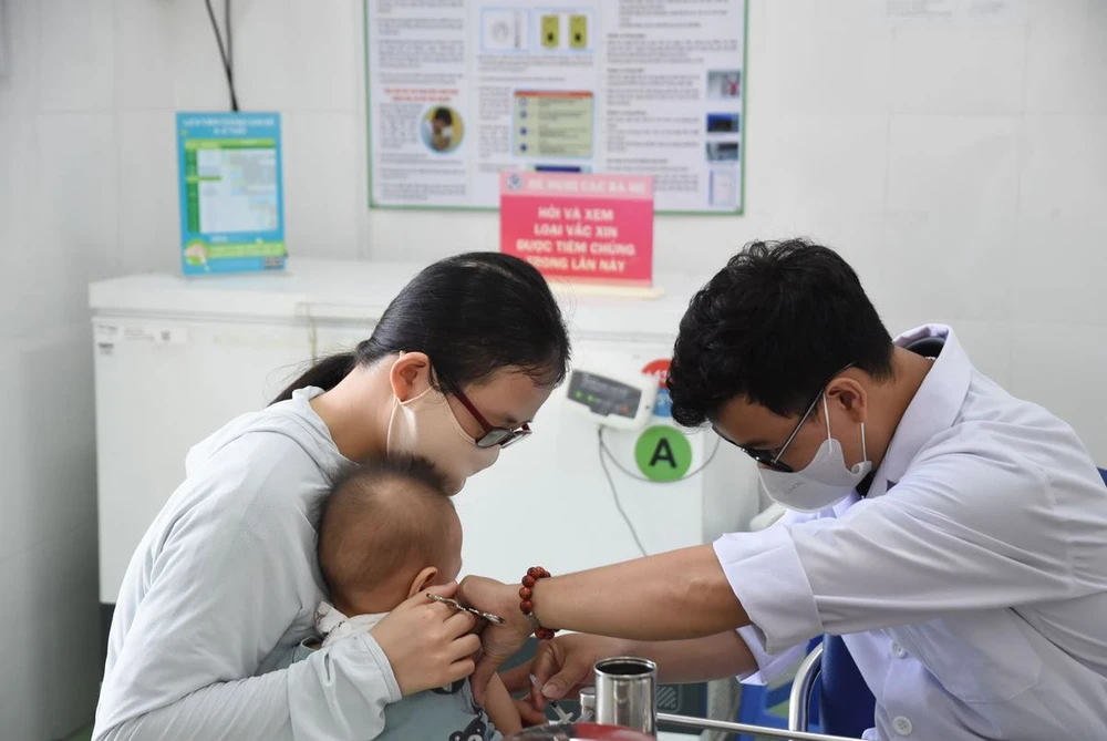 Un petit enfant s'est fait vacciner contre la rougeole au poste médical du quartier Phuoc Long A (ville de Thu Duc). Photo : VNA