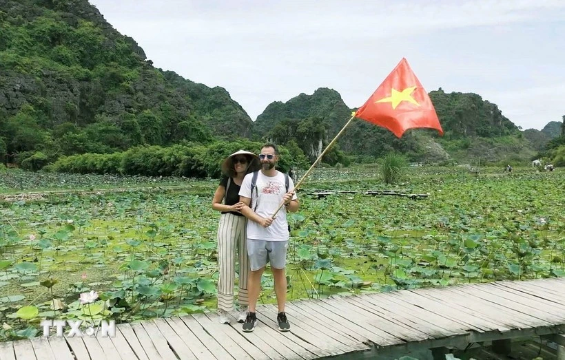 Des touristes étrangers posent pour une photo sur le célèbre Golden Bridge à l'intérieur du complexe Ba Na Hills Sun World dans la ville de Da Nang (Photo : VNA)