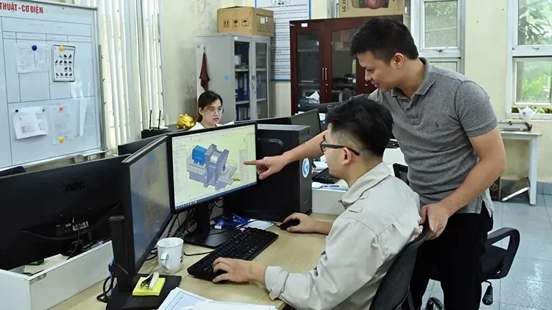 Engineers of Tomeco company in Hanoi's Ngoc Liep Industrial Cluster discuss industrial fan design (Photo: VNA)