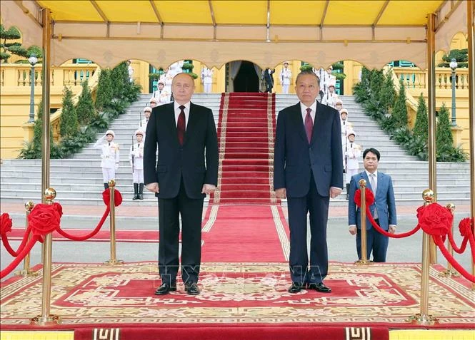 State President To Lam (R) and Russian President Vladimir Putin listen to the two countries’ national anthems (Photo: VNA)