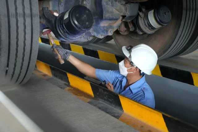 Inspectors check under a truck at Tien Vinh Motor Vehicle Inspection Centre (70-04D) in Tay Ninh province. Older vehicles must undergo strict emission testing under the new law. (Photo: VNA)