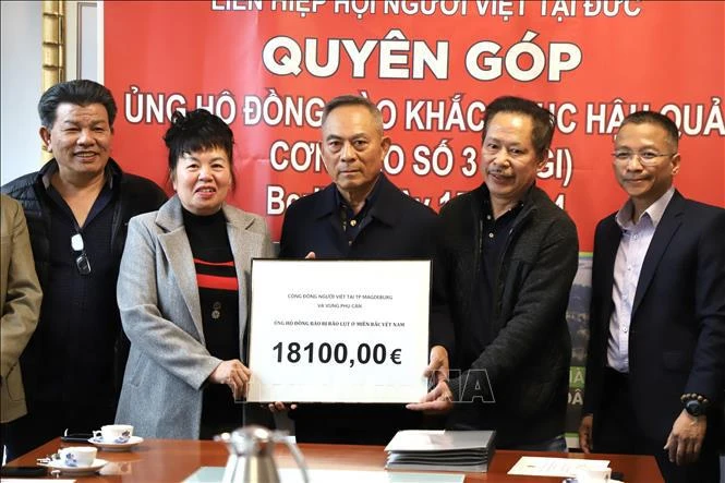 Nguyen Van Hien, president of the union of Vietnamese people associations in Germany, receives a donation of 18,100 EUR from Phan Thi Binh, a representative from Saxony-Anhalt state. (Photo: VNA)