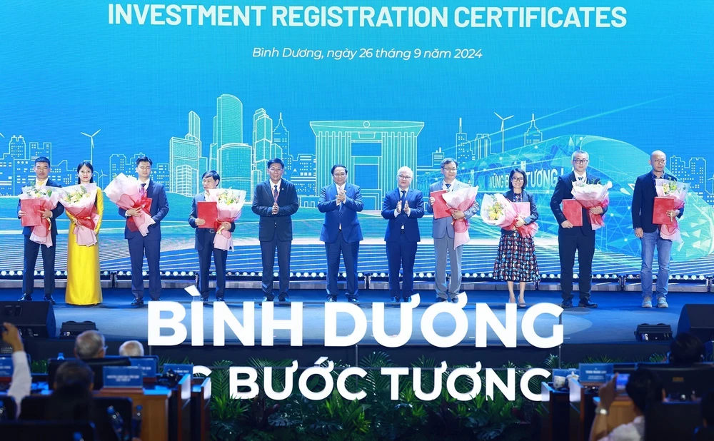 Prime Minister Pham Minh Chinh (C) and investors in Binh Duong province (Photo: VNA)