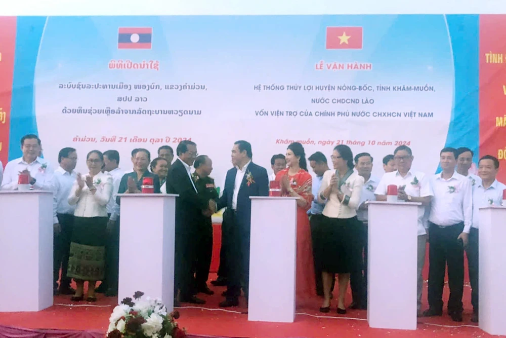 Delegates press buttons to put the irrigation system into operation. (Photo: VNA)