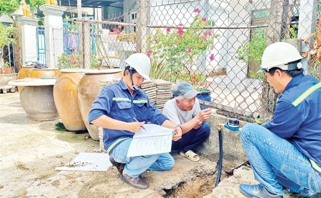 Workers from the Can Gio Clean Water Supply Company install smart water meters in Tam Thon Hiep commune, Can Gio district. (Photo: nhandan.vn) 