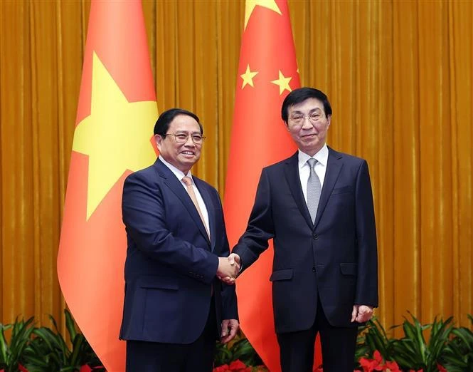 Prime Minister Pham Minh Chinh (L) and Wang Huning, a member of the Standing Committee of the Communist Party of China (CPC) Central Committee’s Political Bureau and Chairman of the Chinese People's Political Consultative Conference (CPPCC) National Committee, at their meeting in Beijing on June 26. (Photo: VNA)