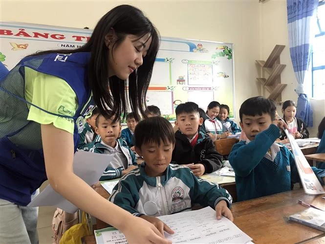 A volunteer student from the Republic of Korea's Gyeongsang National University teaches Korean language for students at the Da Thanh Primary School, Da Lat city, Lam Dong province. (Photo: VNA)