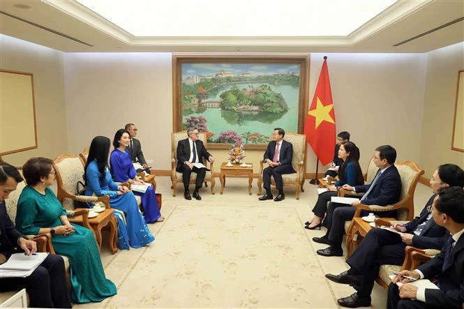 Deputy Prime Minister Le Minh Khai (centre, right) and Group Chairman José Viñals of the UK-based Standard Chartered PLC in Hanoi on June 27. (Photo: VNA)