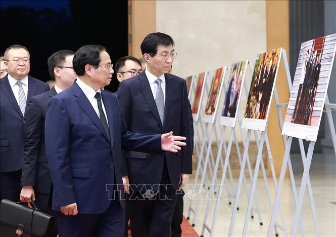 Prime Minister Pham Minh Chinh (1st row, left) introduces Chairman of the Chinese People's Political Consultative Conference (CPPCC) National Committee Wang Huning to photos of some foreign affairs activities of the late Party General Secretary Nguyen Phu Trong. (Photo: VNA)