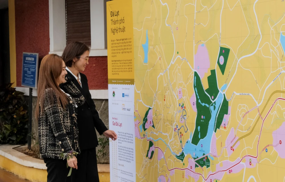 Two women look at the art tourism map of Da Lat. (Photo: baolamdong.vn)