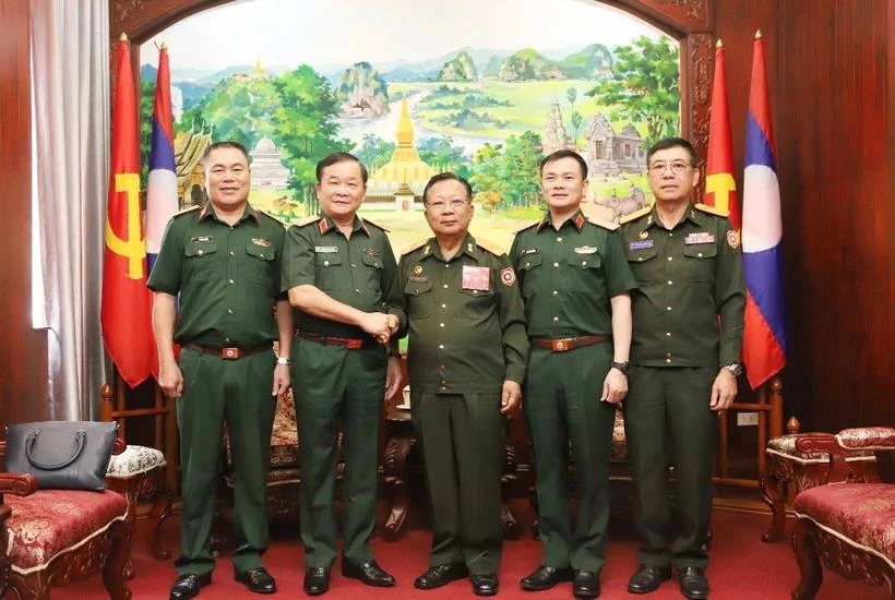 From left: Vietnamese Deputy Minister of National Defence Sen. Lieut. Gen Hoang Xuan Chien (2nd) and Lao Deputy Prime Minister and Minister of National Defence Gen. Chansamone Chanyalath (3rd) in a group photo at their meeting in Vientiane on October 10. (Photo: VNA)