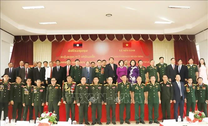 Participants pose for a group photo at the October 24 meeting marking the 75th anniversary of the traditional day of Vietnam’s volunteer soldiers and experts in Laos. (Photo: VNA)