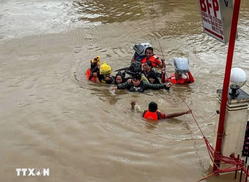 Rescuers evacuate residents from flooded areas due to Typhoon Trami in Camarines Sur province, the Philippines. (Photo: Xinhua/VNA)