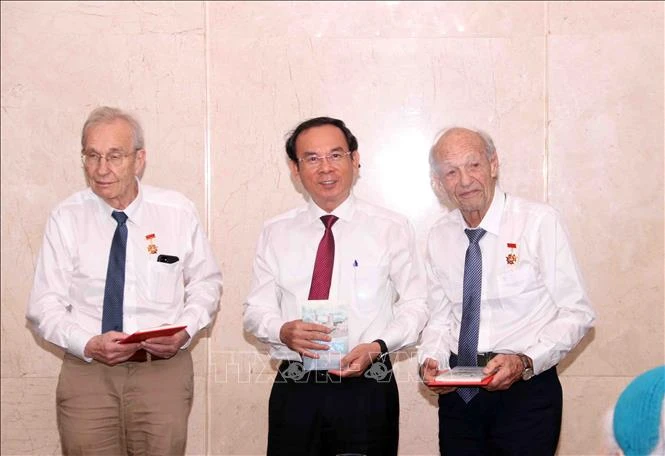 Nguyen Van Nen, Politburo member and Secretary of the Ho Chi Minh City Party Committee, presents the HCM City Badge to Olivier Parriaux and Bernard Bachelard at the meeting. (Photo: VNA)