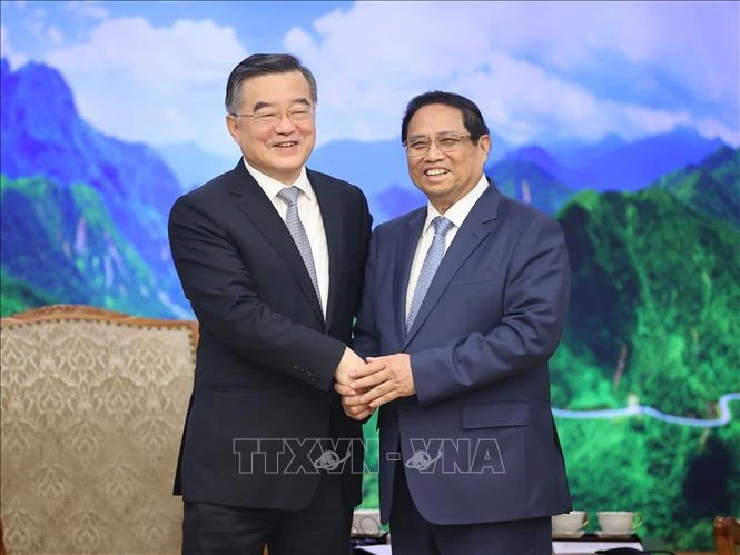 El primer ministro Pham Minh Chinh (D) y el vicepresidente del Comité Permanente de la Asamblea Popular Nacional (APN) de China, Zhang Qingwei. (Foto: VNA)
