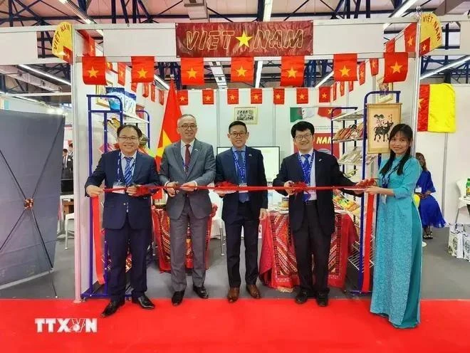 El embajador Tran Quoc Khanh (centro) y el consejero comercial Hoang Duc Nhuan (izquierda) cortaron la cinta para inaugurar el pabellón de Vietnam en la feria. (Foto: VNA)