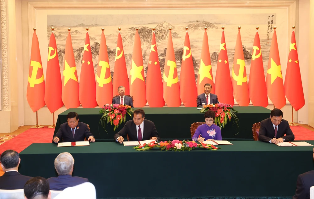 Ceremonia de firma del Acuerdo de Cooperación entre la Agencia Vietnamita de Noticias d y la Agencia de Noticias Xinhua (derecha) y la cooperación en materia de inversiones (izquierda) entre los dos países. (Fuente: VNA)