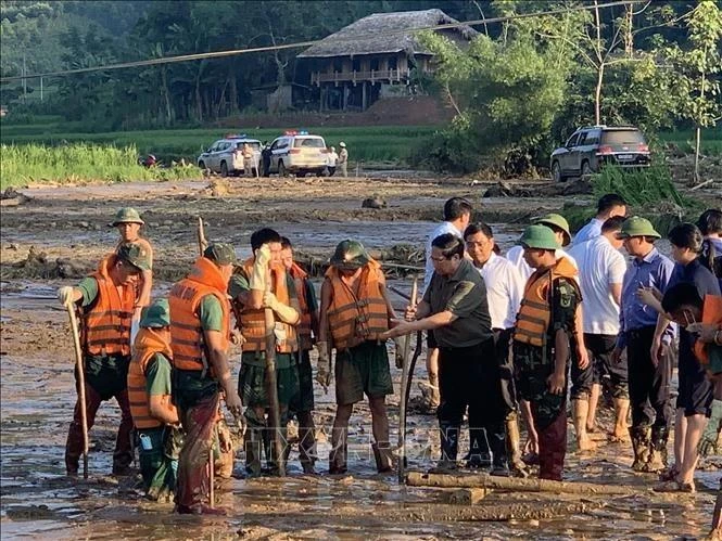 El primer ministro Pham Minh Chinh durante su inspección sobre el terreno de la operación de búsqueda y rescate en la aldea Lang Nu de la provincia de Lao Cai, que fue golpeada por un devastador deslizamiento de tierra que sepultó 37 viviendas y dejó 95 personas muertas o desaparecidas. (Foto: VNA)