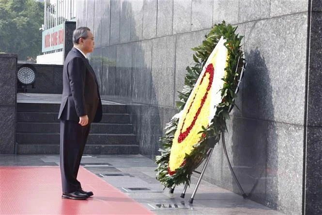 El primer ministro chino Li Qiang rinde homenaje al Presidente Ho Chi Minh en el mausoleo que lleva el nombre del prócer de la independencia de Vietnam en Hanoi. (Foto: VNA)