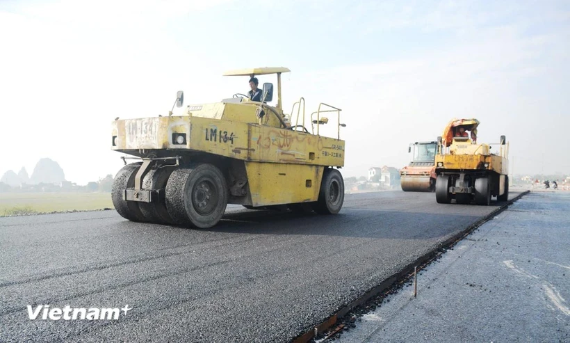 Making an asphalt road section of a project on North-South expressway’s eastern wing (Photo: VietnamPlus)