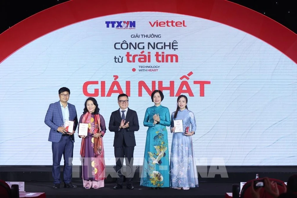 La directrice générale de la VNA, Vu Viêt Trang, également présidente du Conseil du jury, et le président de l'Association des journalistes du Vietnam, Lê Quôc Minh, décernent les trois premiers prix à leurs lauréats. Photo: VNA