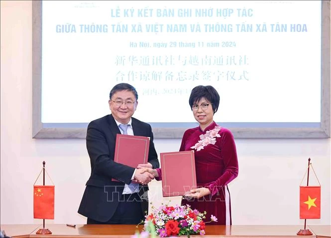 La directrice générale de la VNA Vu Viêt Trang et le rédacteur en chef adjoint de Xinhua Ren Weidong signent un protocole d'accord sur les plans de coopération en 2025. Photo: VNA