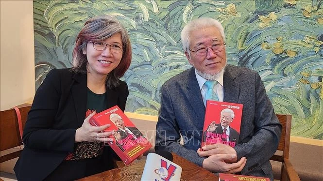 Author Cho Chul-hyeon (R) presents a copy of his book to a Vietnam News Agency reporter in Seoul. Photo: VNA)