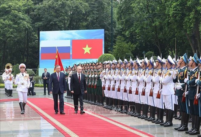 President To Lam and Russian President Vladimir Putin review the Honour Guard of the Vietnam People's Army. (Photo: VNA)