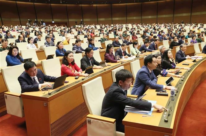 Lawmakers push buttons to adopt laws and resolutions. (Photo: VNA)