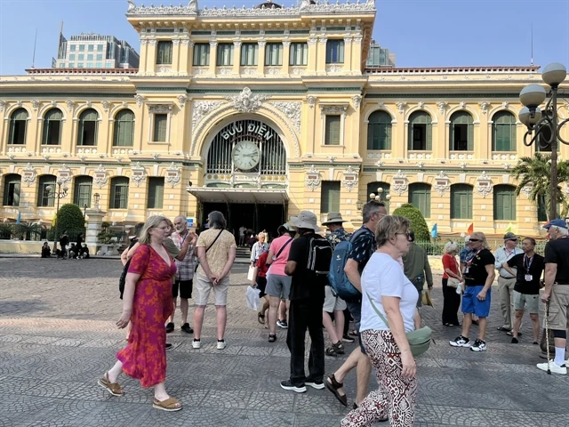 Foreign tourists seen in front of the HCM City Post Office in the downtown area. (Photo: VNA)