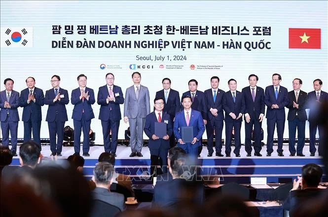 Vietnamese and Korean businesses exchange their cooperation agreements at the Vietnam - RoK Business Forum. (Photo: VNA)