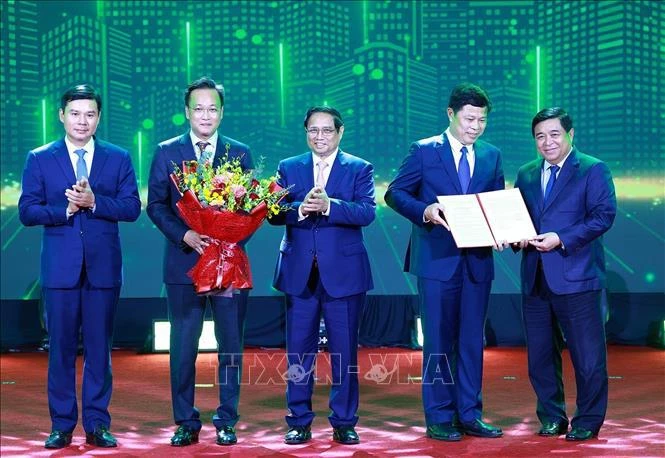 Prime Minister Pham Minh Chinh (C) and Minister of Planning and Investment Nguyen Chi Dung (first, R) present the decision approving Hung Yen's master plan to leaders of Hung Yen (Photo: VNA)