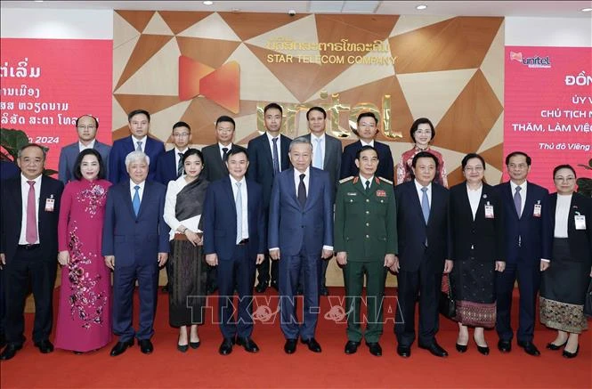 President To Lam (middle, first row) takes a group photo with representatives of Star Telecom (Unitel) as part of his state visit to Laos on July 11. (Photo: VNA)