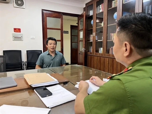 Than Van Thoai, Deputy Director-General of Global BBA JSC, is questioned by a policeman. (Photo sggp.org.vn)