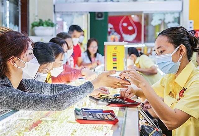 Customers purchase gold rings at a jewellery store. (Photo: cand.com.vn)