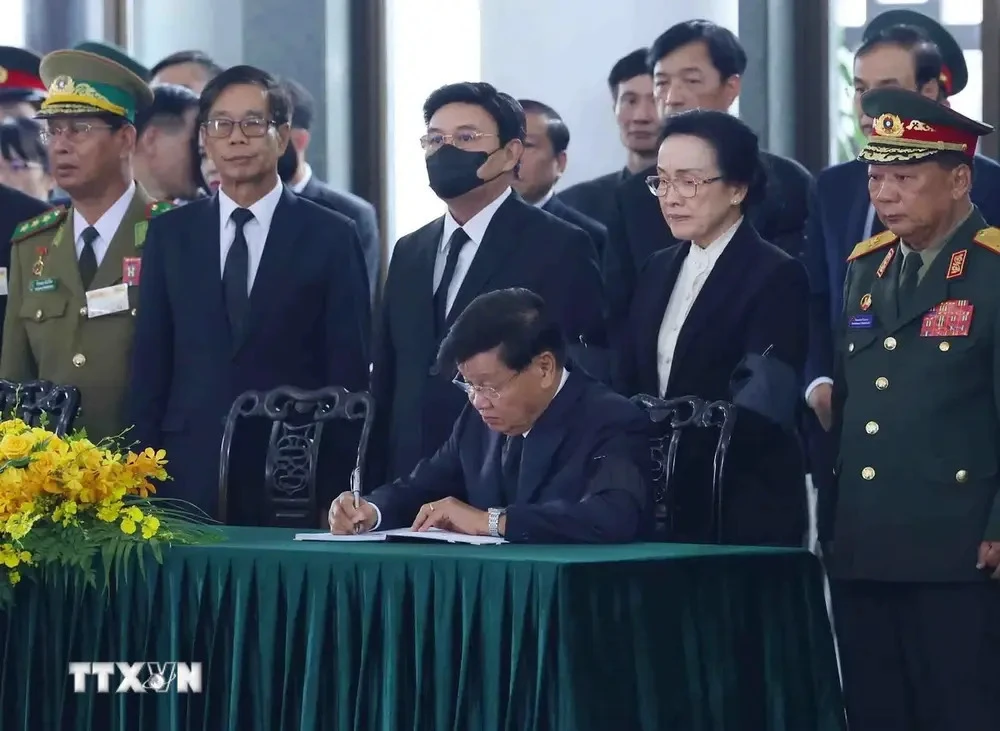 Party General Secretary and President of Laos Thongloun Sisoulith writes in the condolence book (Photo: VNA)