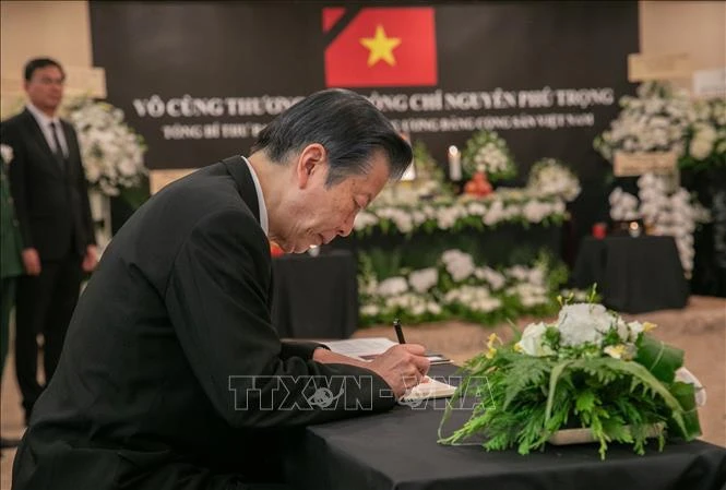 Japanese Senator Natsuo Yamaguchi writes in the condolence book. (Photo: VNA)