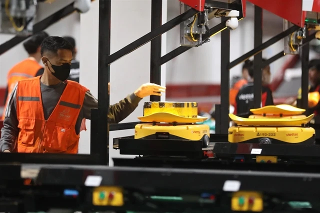 A Viettel Post employee operates automated equipment at its plant (Photo: VNA)