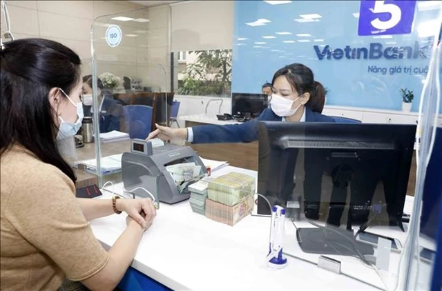 A bank worker with a customer at a VietinBank's office in Hanoi. (Photo: VNA)