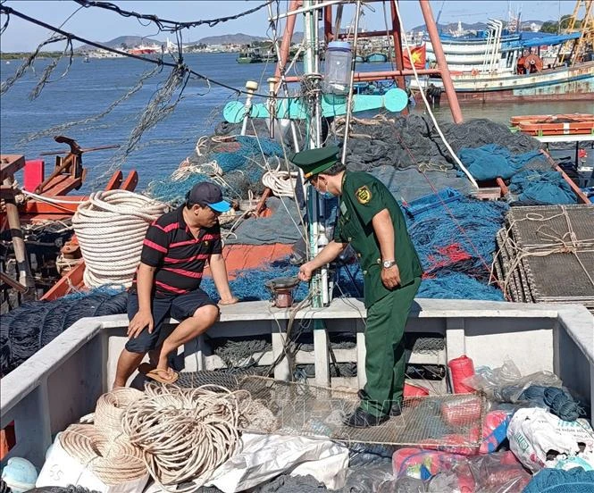 A border guard soldier inspects the installation of the vessel monitoring system (VMS) on a fishing vessel at Cat Lo fishing port. (Photo: VNA)