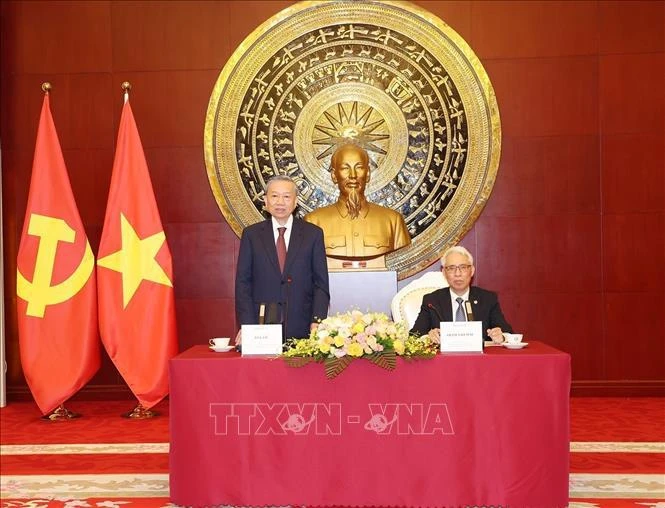 Party General Secretary and State President To Lam (standing) talks with the staff of the Vietnamese Embassy and representatives of the Vietnamese community in China. (Photo: VNA)