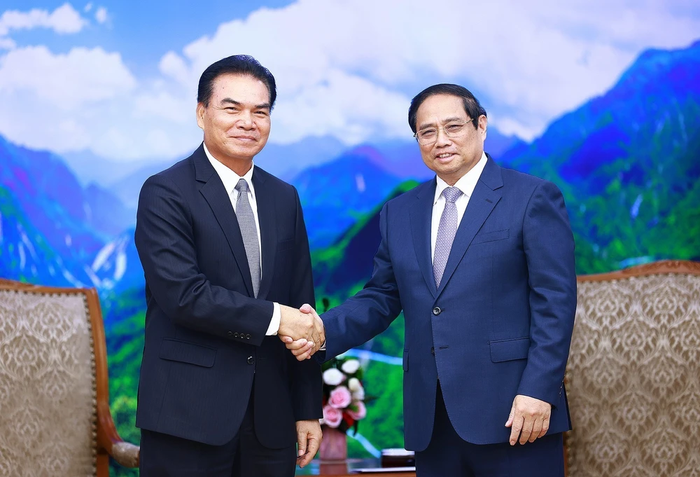 Prime Minister Pham Minh Chinh (R) and visiting Lao Minister of Planning and Investment and Chairman of the Laos-Vietnam Cooperation Committee Phet Phomphiphak at their meeting in Hanoi on August 19. (Photo: VNA).