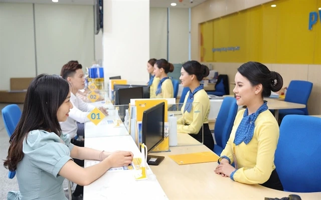 Customers make transactions at a bank in Hanoi. (Photo: chinhphu.vn)