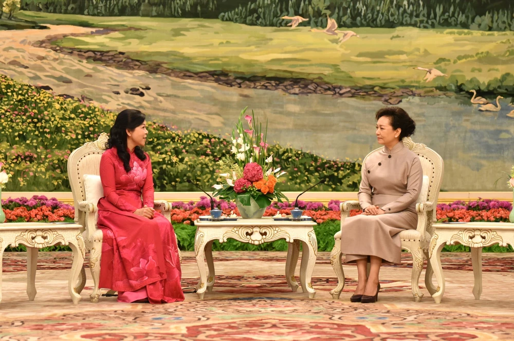 Professor Peng Liyuan, the wife of General Secretary of the Communist Party of China (CPC) Central Committee and President Xi Jinping (R) hosts tea party for the wife of General Secretary of the Communist Party of Vietnam (CPV) Central Committee and State President To Lam, Ngo Phuong Ly (Photo: VNA)