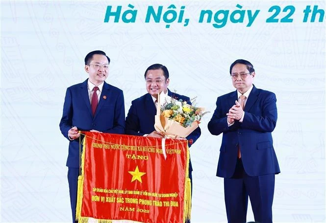 Prime Minister Pham Minh Chinh (1st from right) presents the Government's emulation flag to the representative of the Vietnam National Chemical Group. (Photo: VNA) 