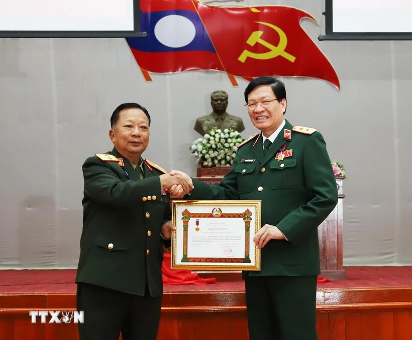 Lao Deputy Prime Minister and Minister of National Defence Gen. Chansamone Chanyalath presents a first-class Labour Order to VMMU Director Nguyen Xuan Kien. (Photo: VNA)