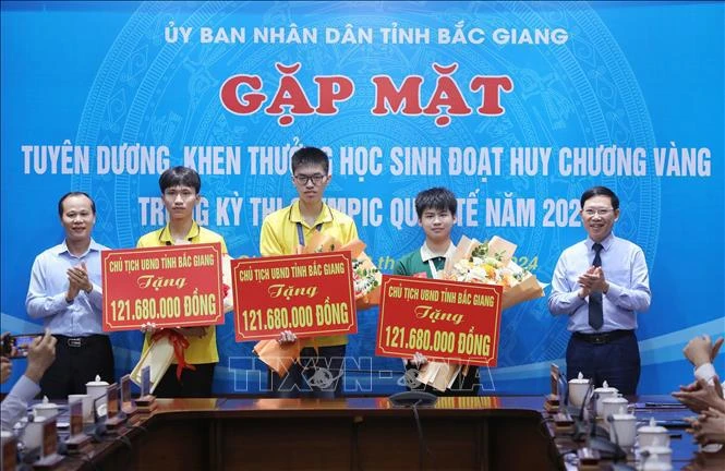 Three students who won gold medals at this year's International Olympiads receive awards at the ceremony (Photo: VNA) 